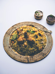 Delicious spicy chicken biryani in bowl over moody background, it’s a popular Indian and Pakistani food.