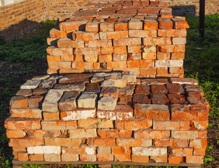 Pile of old red bricks on the pallet on the sunset, close up