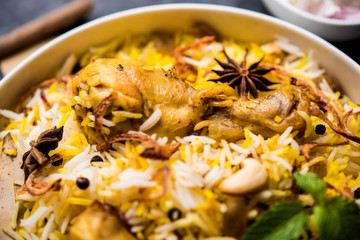 Delicious spicy chicken biryani in bowl over moody background, it’s a popular Indian and Pakistani food.
