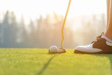 Cercles muraux Golf Femme asiatique à la main mettant une balle de golf sur un tee avec un club dans un parcours de golf le soir pour un sport sain. Concept de mode de vie