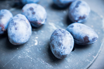 Fresh ripe plums on the rustic background. Selective focus. Shallow depth of field.