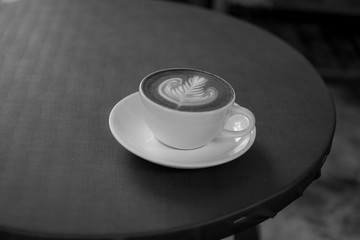 A white cup of coffee is placed on a gray table.