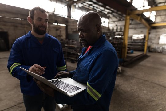 Two blacksmith discussing over laptop