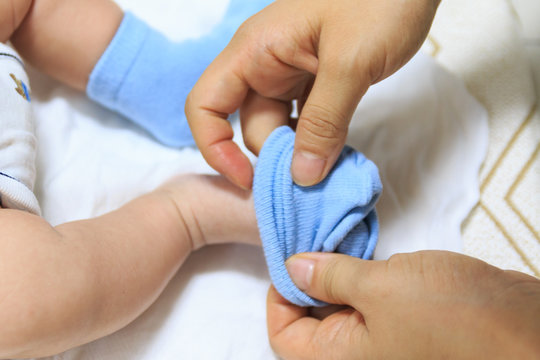 Parent Putting On Her Cute Baby Socks