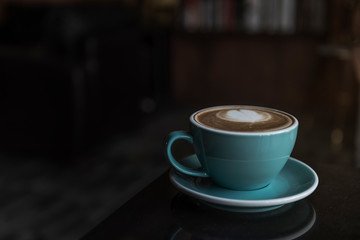 Latte coffee cups placed on a black stone table.