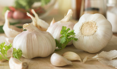 Group of garlic with blur vegetable on chopping board in kitchen room.Food and ingredient concepts
