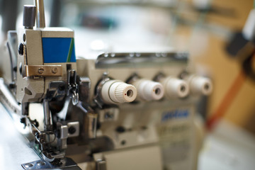 Fototapeta na wymiar closeup details on sewing machine overlock. Workplace seamstress.Tailoring industry
