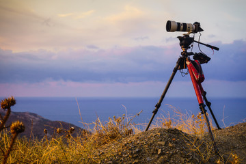 Camera taking picture film of sunrise over sea surface