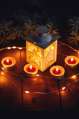Christmas lantern with four candles on a wooden board, top view