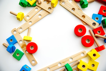 Closeup of toy wooden bricks and sticks on white table background. Top view. Flat lay. Copy space for text