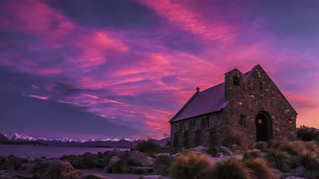 Timelapse of Church of the Good Shepherd on the bank of beautiful Lake Tekapo underneath spectacular purple sky just before the sunrise. One of the iconic landmarks in New Zealand.