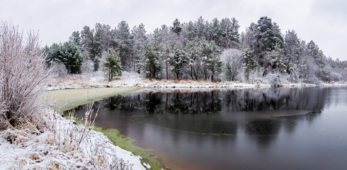 ноябрьский пейзаж на Уральском озере с заснеженным лесом на берегу озера, Россия, ноябрь
