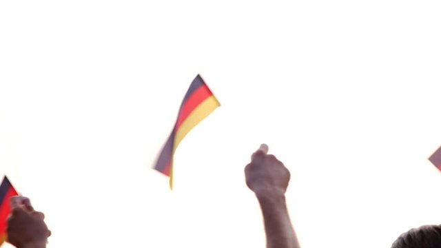 German patriots with flags outdoors. Patriotic Deutsch people waving with small flags. Day of German Unity Celebrations.