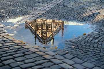 Spiegelbild der Fassade des St. Paul-Domes in einer Wasserpfütze, Münster, Westfalen, Deutschland