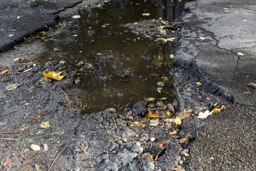 large pit with stones on the asphalt road