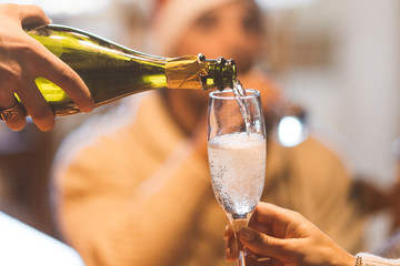 Christmas celebration with champagne - group of friends drinking and toasting together - a hand...