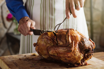 Man carving turkey at table