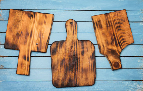 Three empty cutting boards on blue wooden chabby background.