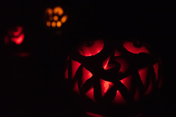 A trio of Halloween Jack o' Lanterns glowing in the night.