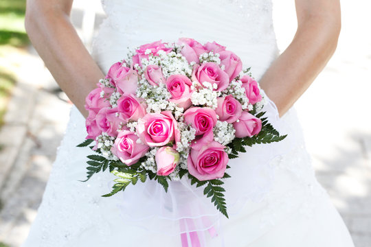 Bouquet di colore bianco e rosa  shocking tenuto in mano  da una sposa