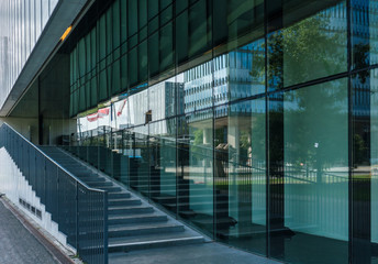 Geometric lines in Modern Architecture. Reflection of clouds in glass windows and green lawn in front. Technical University of Eindhoven, Netherlands.