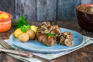 Beef roulade staffed with mushrooms in creamy mushroom sauce served with boiled baby potatoes