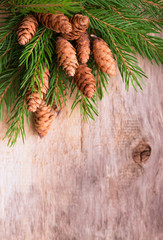 Christmas wooden background with fir branches and cones