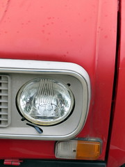 Roter französischer Kleinwagen Klassiker mit rundem Scheinwerfer und mattem Lack vor einer...
