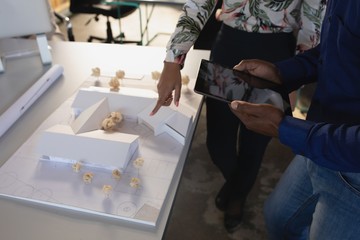 Executives discussing over house model in office