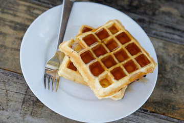 Plate of Waffles Outside with a Fork and Syrup and Pecans