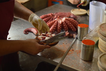 Cooks Chopping Octopus At Becerrea Octopus Fair. Cooking, Food, Travel, Professions. August 3, 2018. Becerrea, Lugo, Galicia, Spain.