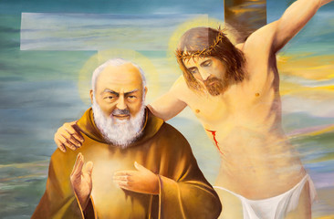 REGGIO EMILIA, ITALY - APRIL 12, 2018: The modern painting of Pater Pio with the Jesus on the corss...