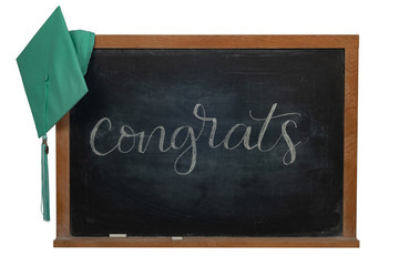 Congrats written in white chalk on a black chalkboard with a green graduation cap hanging on the...