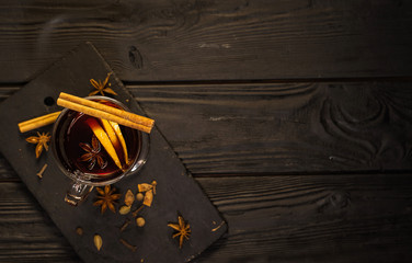 mulled wine on black wooden table, cinnamon sticks and orange, top view,  mulled wine set, place...