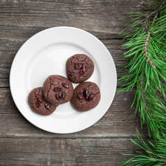 Christmas background with chocolate cookies with cranberry and fir branches