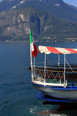Fototapeta na wymiar traghetto con bandiera italiana sul lago di como, ferry boat with Italian flag on Lake of Como