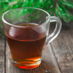 Tea in glass cup on wooden table background.