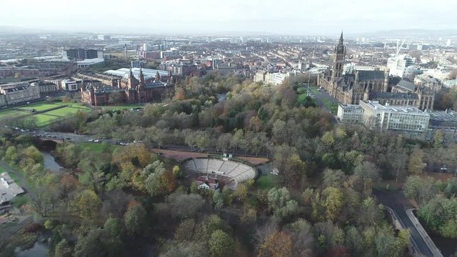 Aerial footage from over Kelvingrove Park in Glasgow. With view to the Art Gallery and Museum, bandstand, Glasgow University Tower and the cityscape.