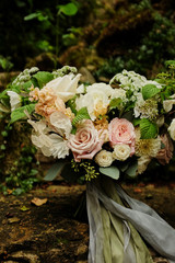 Bright romantic bouquet of flowers with ribbons on the background of the garden. fine art style