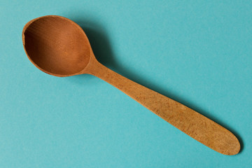 Old wooden spoon. Isolated on blue background