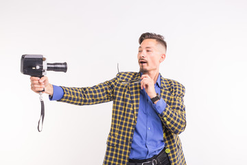 Technologies, photographing and people concept - portrait of funny young brunette man taking selfie with camera on white background