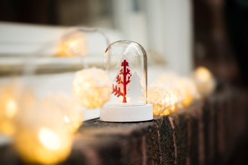 Christmas snow globe with trees and lights on a window, brick wall. Copy space