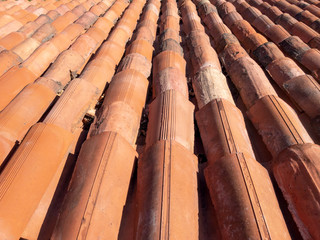 The surface of the roof of the red semi-circular clay tiles. Background, longitudinal arrangement of tiles, close up