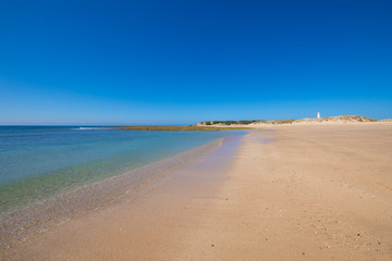 lonely Cala Marisucia and Trafalgar lighthouse from seashore