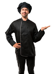 Chef man In black uniform holding copyspace imaginary on the palm to insert an ad on isolated white...