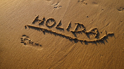 Schriftzug Holiday am Sandstrand von R&uuml;gen gezeichnet