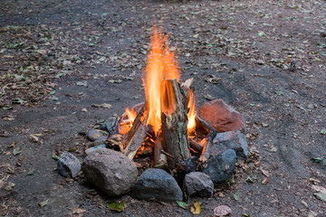 Campfire ablaze with stone circle at daylight with earth background - 231739117