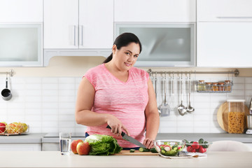 Woman preparing vegetable salad on table in kitchen. Healthy diet