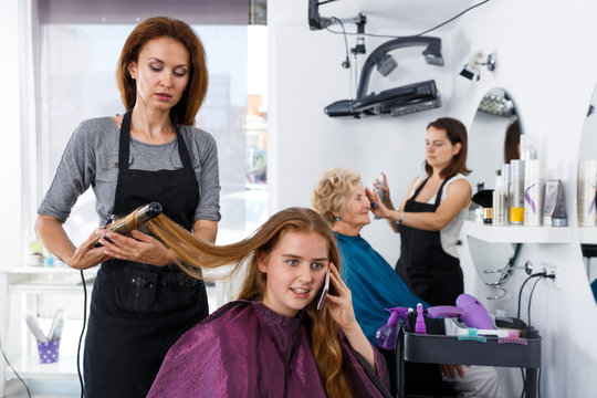Girl talking on phone in hair salon