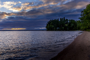 Dramatic cloudscape at sunset above a lake in Ontario Canada at a rainy day in fall.
